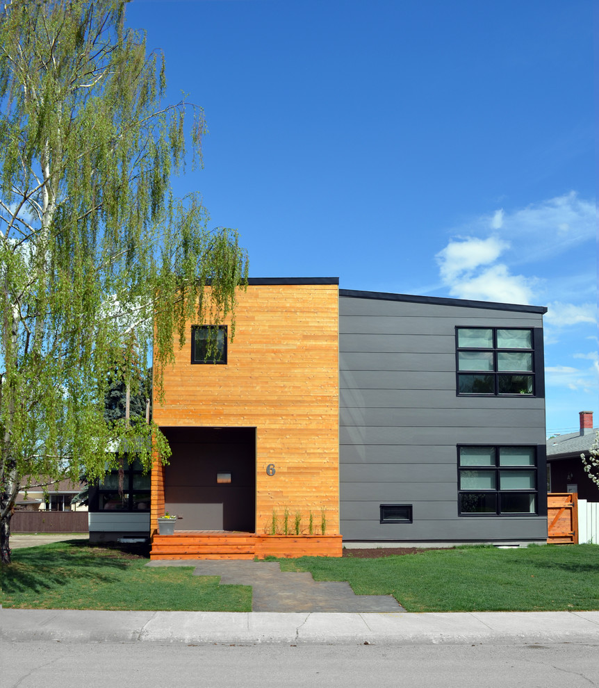 Photo of a contemporary two-storey grey exterior in Calgary with mixed siding.