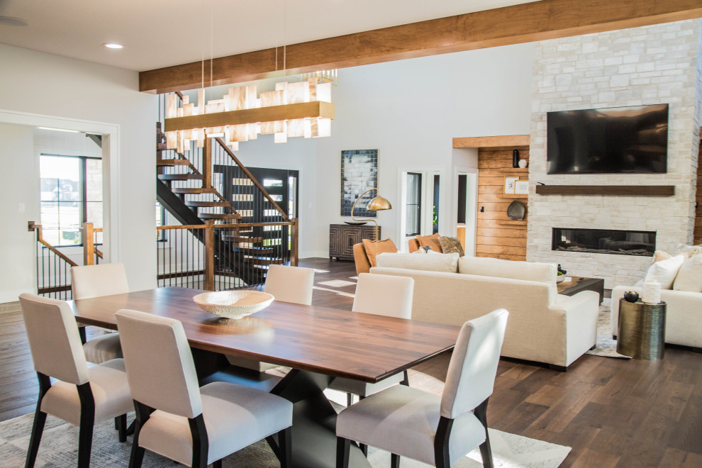 На фото: огромная кухня-столовая в стиле модернизм с белыми стенами, паркетным полом среднего тона, коричневым полом и балками на потолке с