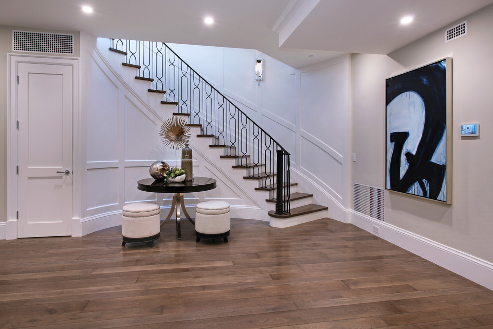 Large trendy wooden curved staircase photo in Orange County with wooden risers