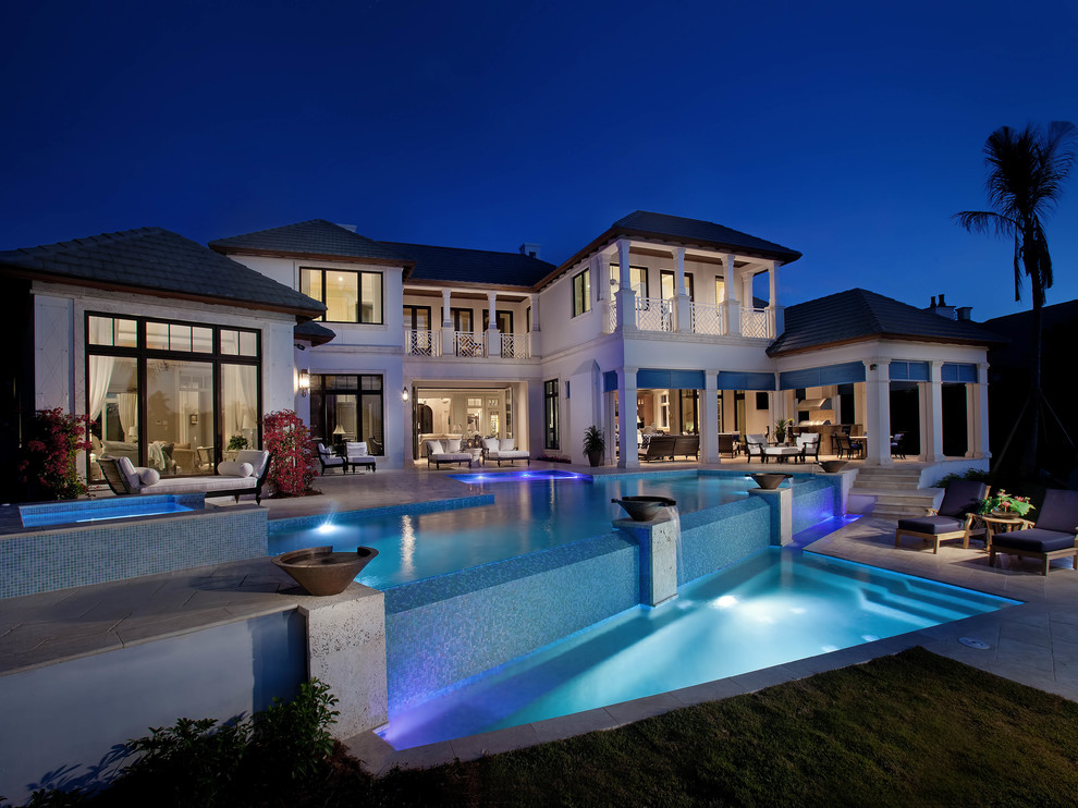 Large tropical backyard custom-shaped infinity pool in Miami.