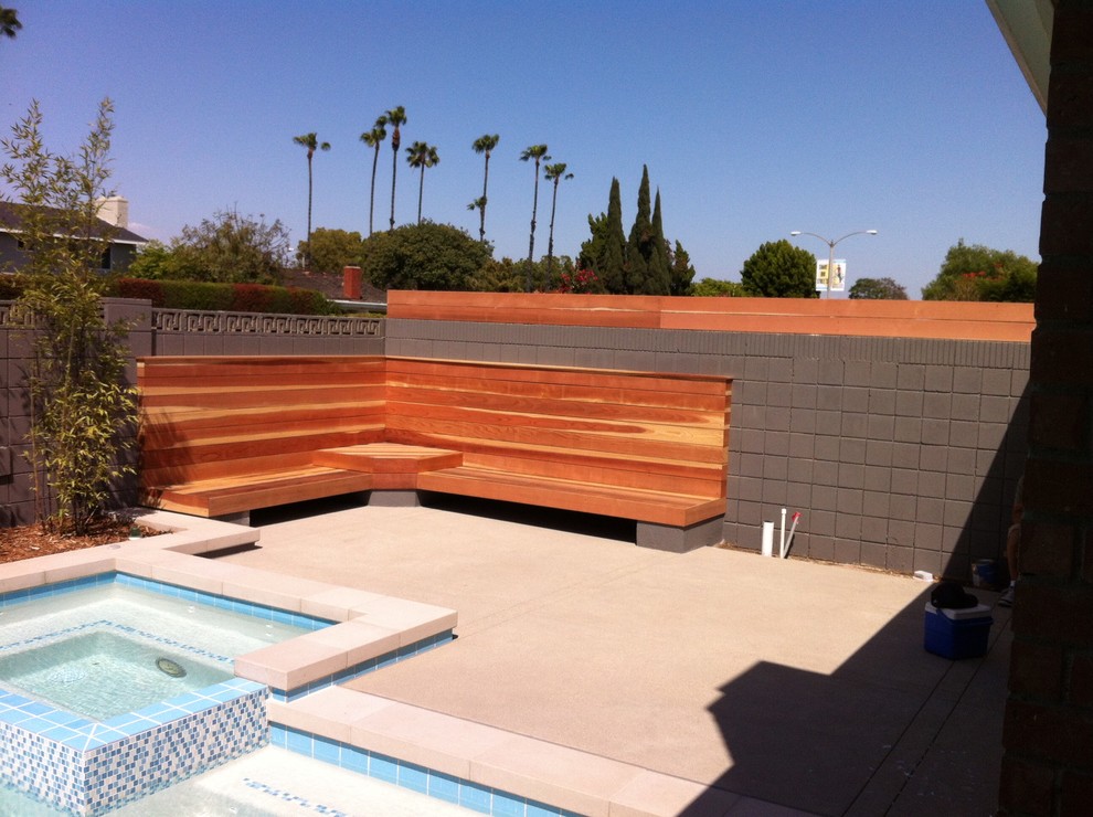 Design ideas for a small modern backyard rectangular pool in Los Angeles with concrete slab and a hot tub.