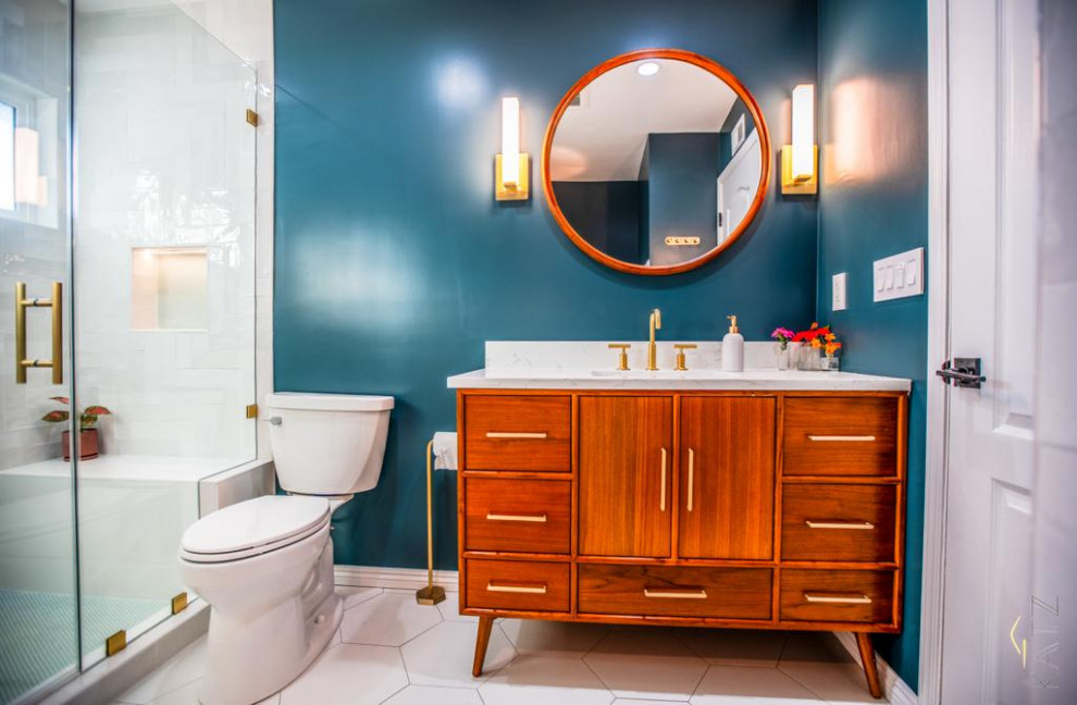 Exemple d'une salle d'eau bord de mer de taille moyenne avec une baignoire indépendante, une douche d'angle, WC à poser, un carrelage blanc, du carrelage en marbre, un mur bleu, un plan de toilette en marbre, un sol blanc, une cabine de douche à porte battante, un plan de toilette blanc, meuble simple vasque et meuble-lavabo sur pied.