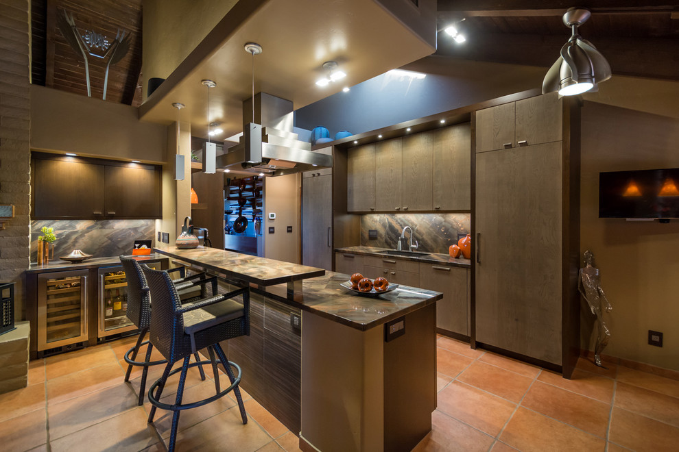 This is an example of a large contemporary l-shaped kitchen in Phoenix with flat-panel cabinets, medium wood cabinets, an undermount sink, onyx benchtops, brown splashback, stone slab splashback, terra-cotta floors and red floor.