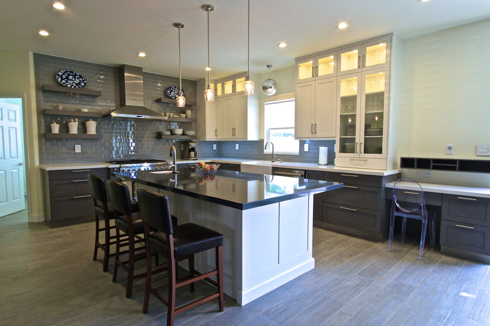 Example of a transitional porcelain tile kitchen design in Orange County with an island