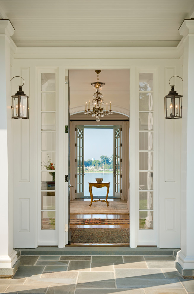 This is an example of an expansive traditional foyer in Baltimore with white walls, light hardwood floors and a single front door.