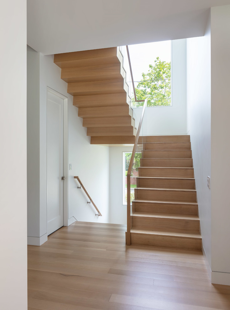 Inspiration for a large contemporary wood u-shaped staircase in Providence with wood risers and mixed railing.