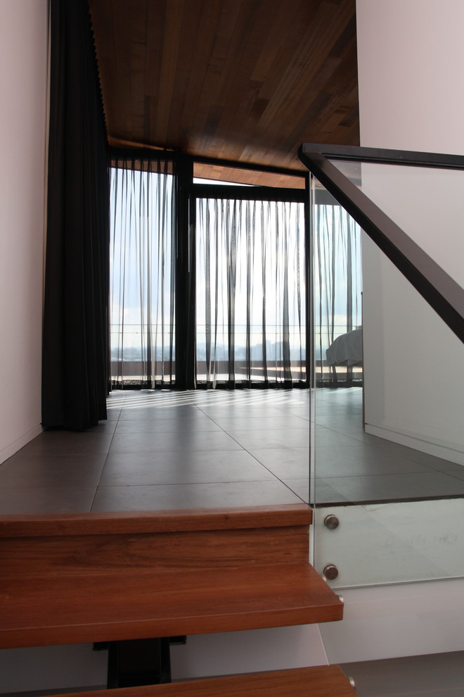 Photo of a large contemporary master bedroom in Adelaide with ceramic floors and grey floor.