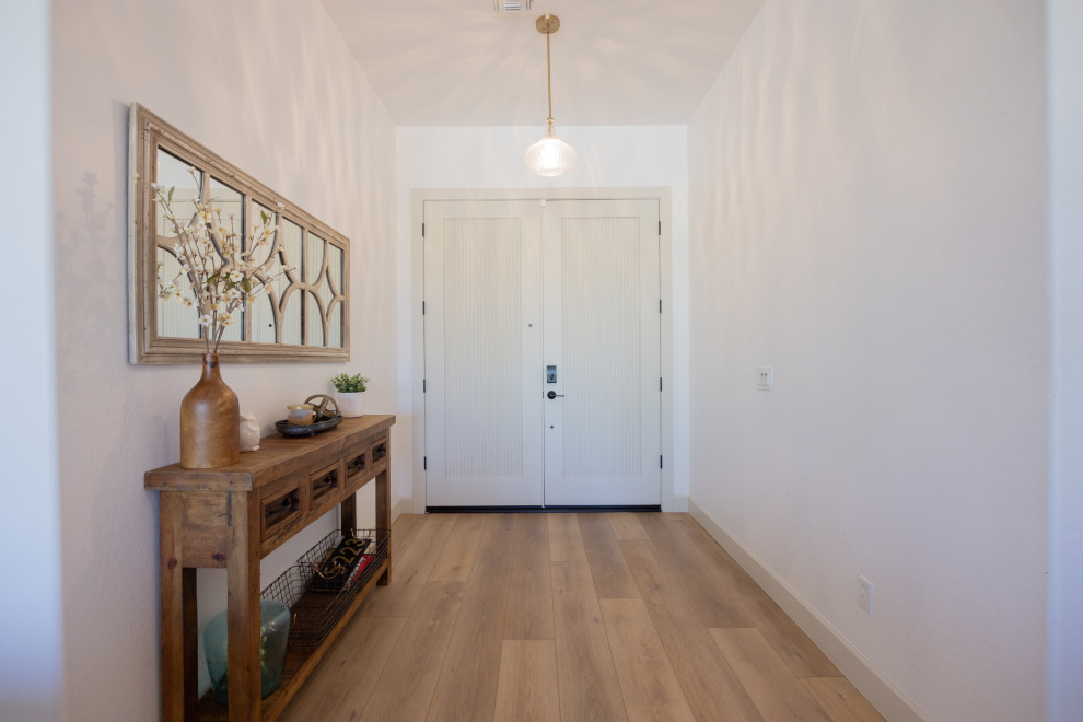 Idée de décoration pour une petite porte d'entrée nordique avec un mur blanc, un sol en vinyl, une porte hollandaise, une porte blanche, un sol beige et un plafond voûté.