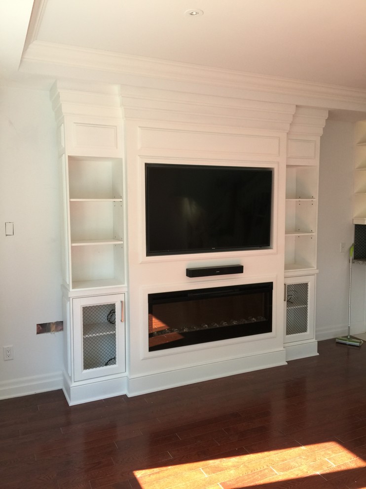 This is an example of a traditional family room in Toronto with a ribbon fireplace, a wood fireplace surround and a built-in media wall.