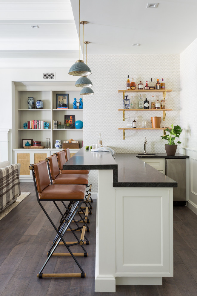 Design ideas for a small transitional l-shaped seated home bar in Los Angeles with shaker cabinets, white cabinets, soapstone benchtops, medium hardwood floors, brown floor and grey benchtop.