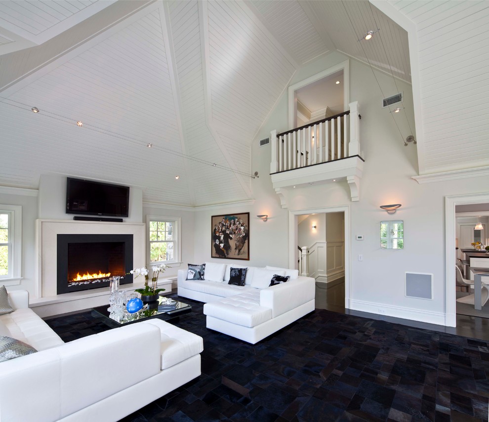 Photo of a contemporary living room in New York with white walls, a standard fireplace and a wall-mounted tv.