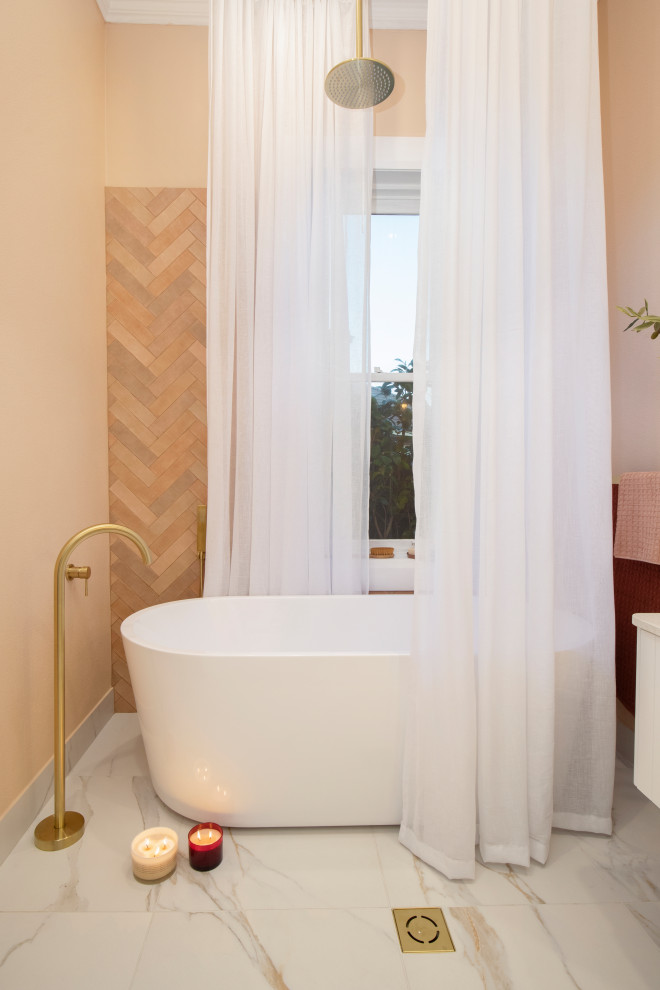 На фото: маленькая главная ванная комната в современном стиле с белыми фасадами, отдельно стоящей ванной, душем над ванной, унитазом-моноблоком, оранжевой плиткой, керамической плиткой, оранжевыми стенами, мраморным полом, настольной раковиной, столешницей из искусственного кварца, белым полом, шторкой для ванной, белой столешницей, тумбой под одну раковину, подвесной тумбой и любой отделкой стен для на участке и в саду