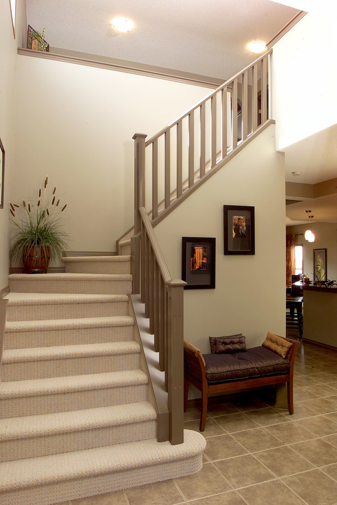Mid-sized transitional carpeted l-shaped staircase in Calgary with carpet risers.