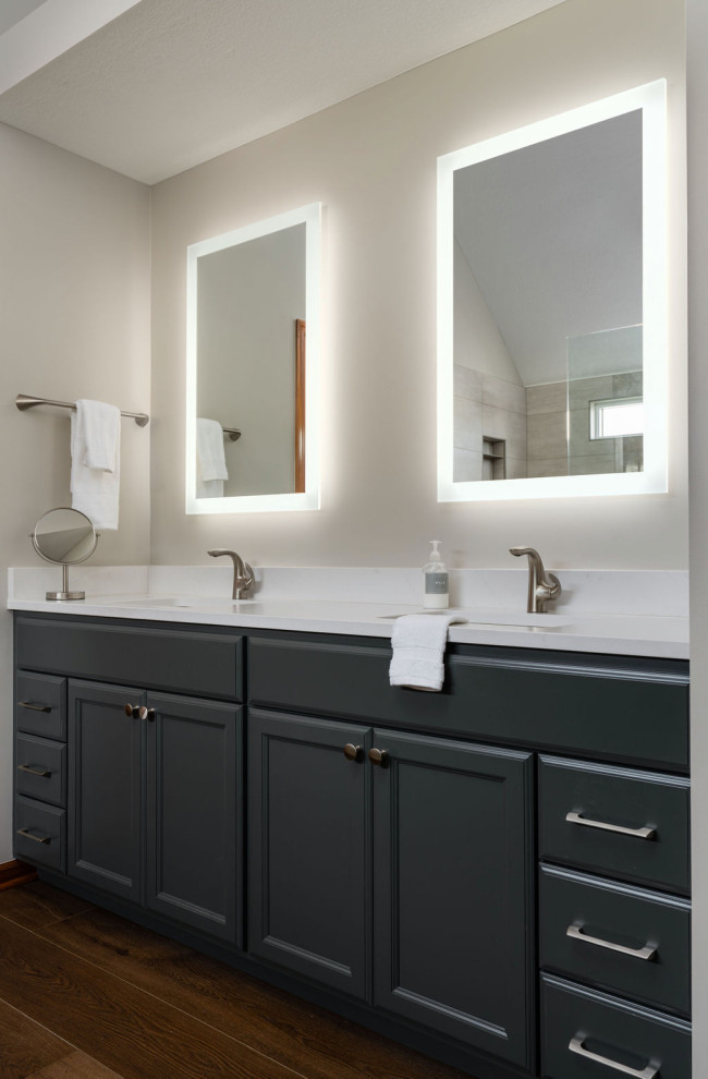 Inspiration for a large traditional ensuite bathroom in Columbus with recessed-panel cabinets, blue cabinets, white walls, a submerged sink, engineered stone worktops, brown floors, white worktops, double sinks, a built in vanity unit and medium hardwood flooring.