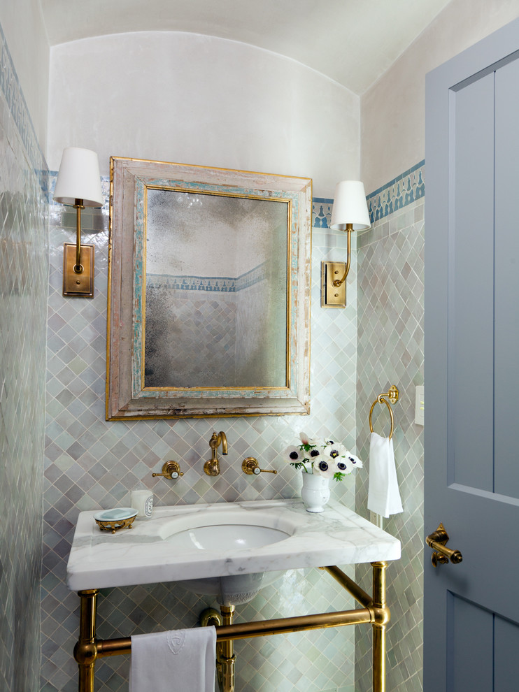 This is an example of a mediterranean powder room in Orange County with a console sink.