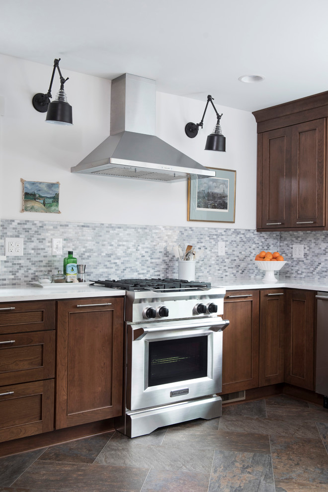 Mid-sized transitional u-shaped vinyl floor and multicolored floor kitchen photo with an undermount sink, shaker cabinets, brown cabinets, quartz countertops, gray backsplash, marble backsplash, stainless steel appliances, no island and white countertops