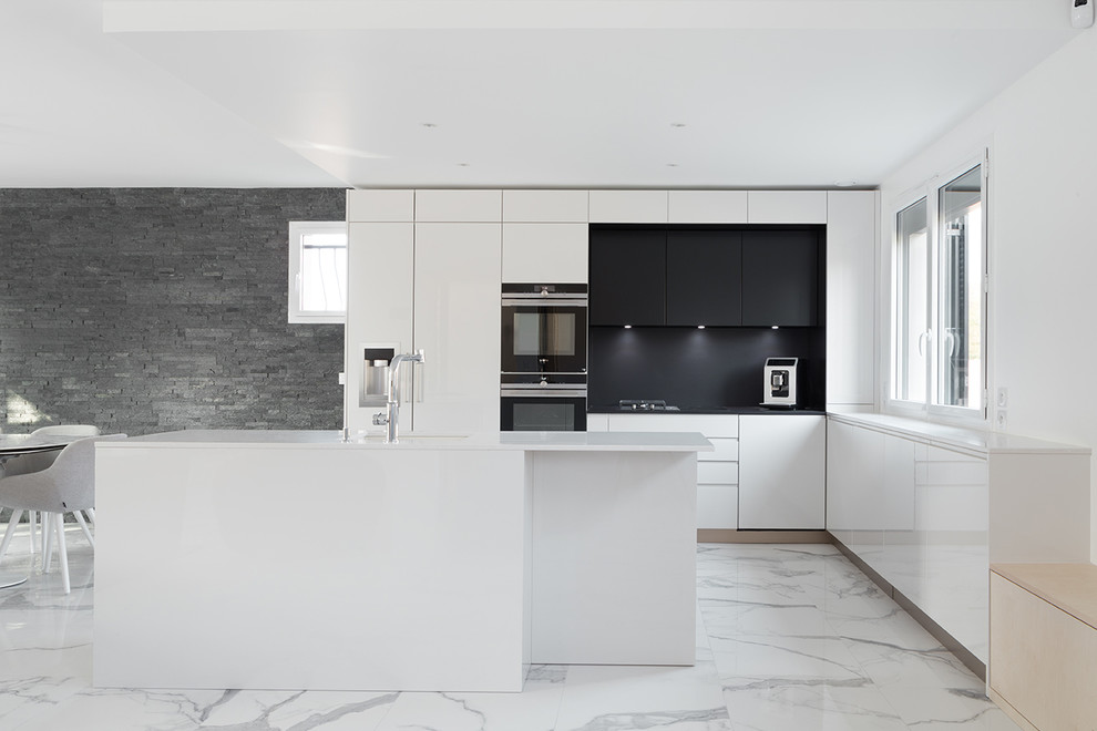 Mid-sized l-shaped eat-in kitchen in Paris with an undermount sink, beaded inset cabinets, white cabinets, granite benchtops, black splashback, slate splashback, with island, white floor and black benchtop.