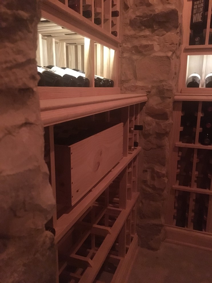This is an example of a large traditional wine cellar in Cincinnati with concrete floors, storage racks and grey floor.