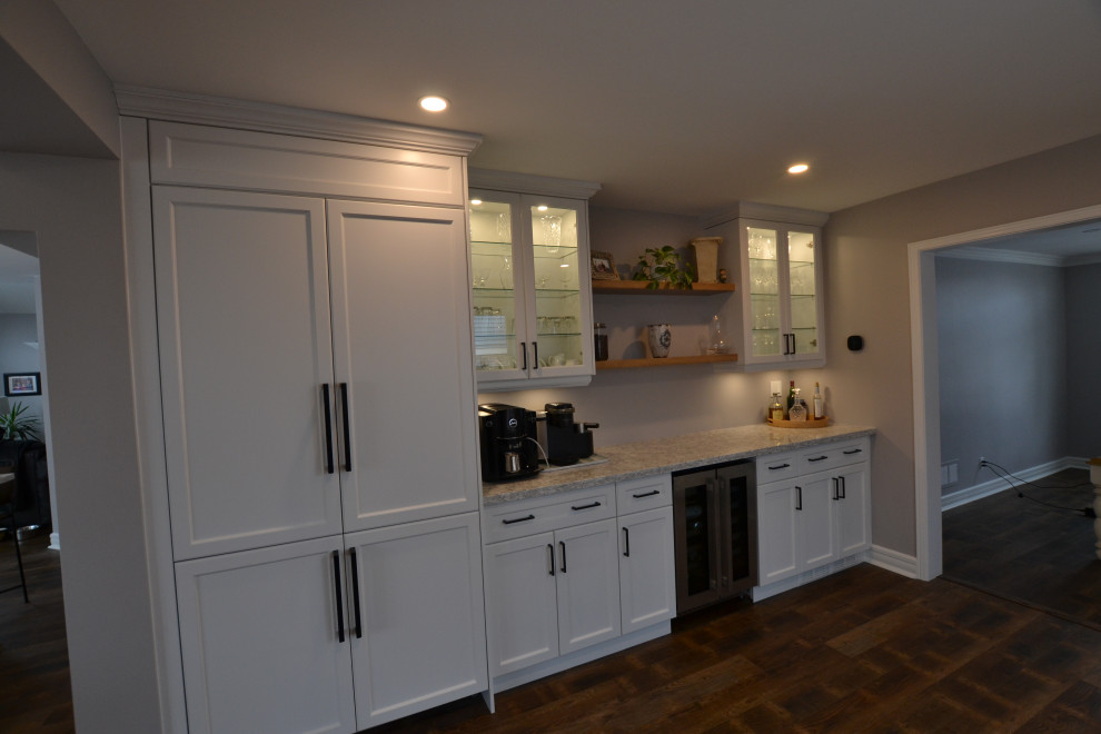 This is an example of a large country home bar in Toronto with an undermount sink, flat-panel cabinets, white cabinets, glass benchtops, grey splashback, ceramic splashback and grey benchtop.