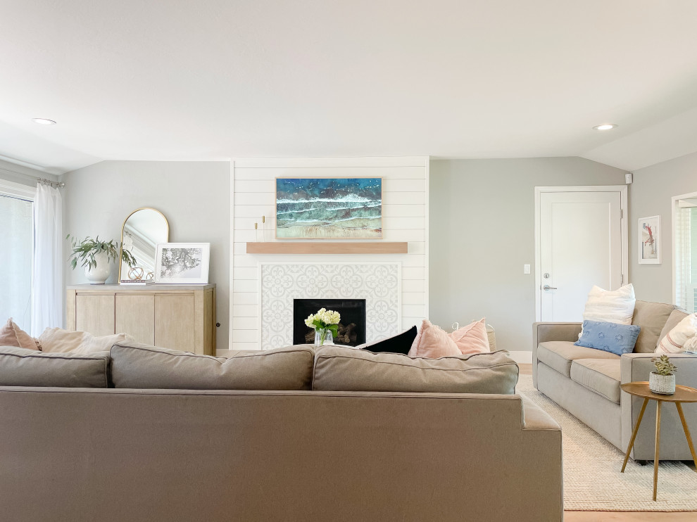 Свежая идея для дизайна: гостиная комната в стиле неоклассика (современная классика) с серыми стенами, светлым паркетным полом, фасадом камина из вагонки и скрытым телевизором - отличное фото интерьера