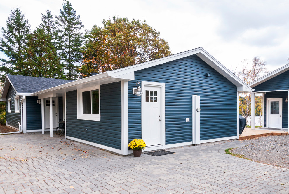 Design ideas for a mid-sized traditional one-storey blue exterior in Other with vinyl siding and a gable roof.