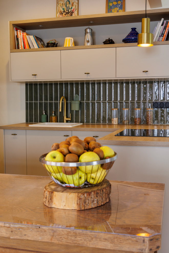 Immagine di una cucina moderna con top in legno, paraspruzzi verde, pavimento in cementine, 2 o più isole e top beige
