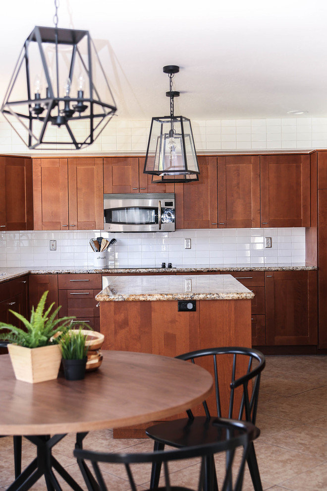 Design ideas for a mid-sized midcentury u-shaped open plan kitchen in Phoenix with a single-bowl sink, shaker cabinets, brown cabinets, granite benchtops, white splashback, subway tile splashback, stainless steel appliances, porcelain floors, with island, beige floor and beige benchtop.