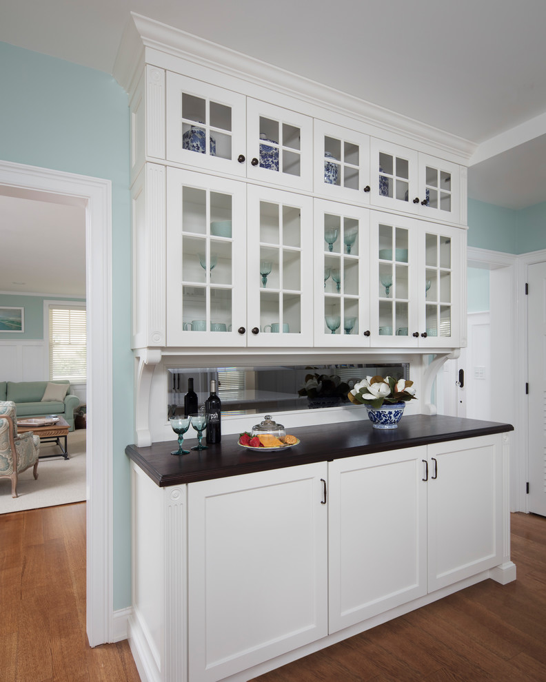 Eat-in kitchen - large transitional galley medium tone wood floor and brown floor eat-in kitchen idea with recessed-panel cabinets, white cabinets, a farmhouse sink, quartz countertops, white backsplash, subway tile backsplash, paneled appliances and an island
