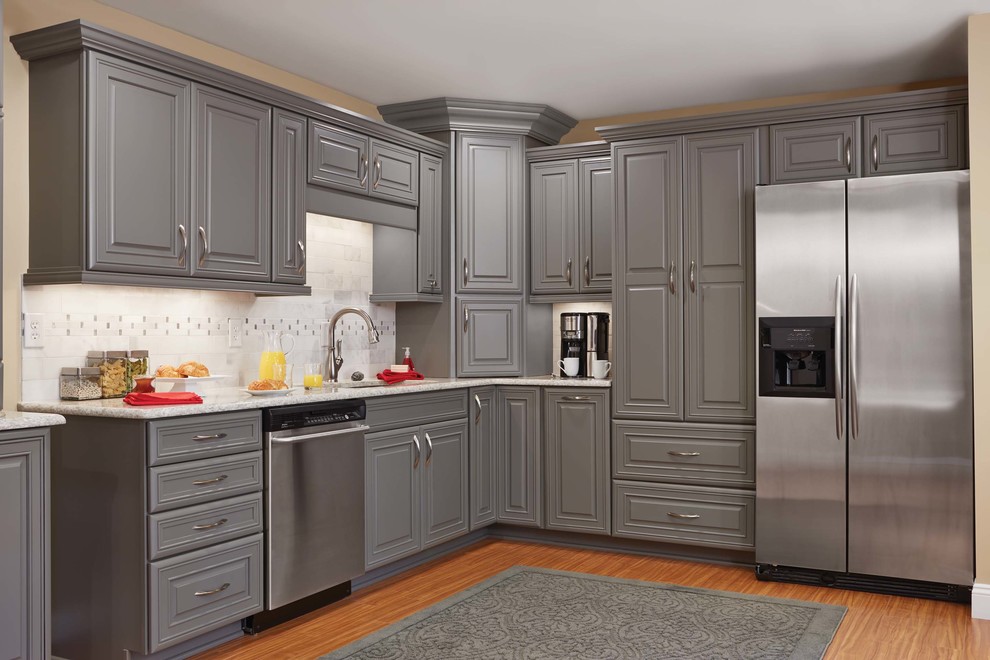 Eat-in kitchen - mid-sized transitional l-shaped medium tone wood floor eat-in kitchen idea in Orange County with an undermount sink, raised-panel cabinets, gray cabinets, quartz countertops, white backsplash, subway tile backsplash, stainless steel appliances and no island