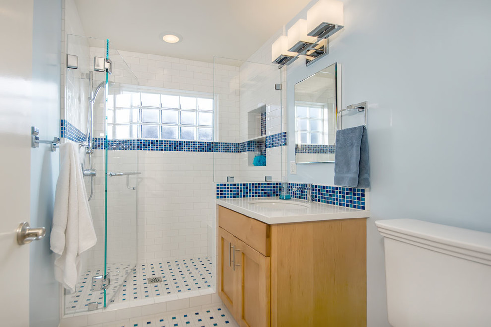 Inspiration for a mid-sized traditional kids bathroom in San Francisco with shaker cabinets, brown cabinets, an alcove shower, a two-piece toilet, blue tile, porcelain tile, blue walls, porcelain floors, an undermount sink, quartzite benchtops, multi-coloured floor, a hinged shower door and beige benchtops.