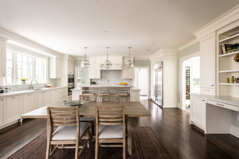 Photo of an expansive traditional l-shaped eat-in kitchen in Boston with an undermount sink, beaded inset cabinets, white cabinets, marble benchtops, grey splashback, marble splashback, stainless steel appliances, dark hardwood floors, with island, brown floor and white benchtop.