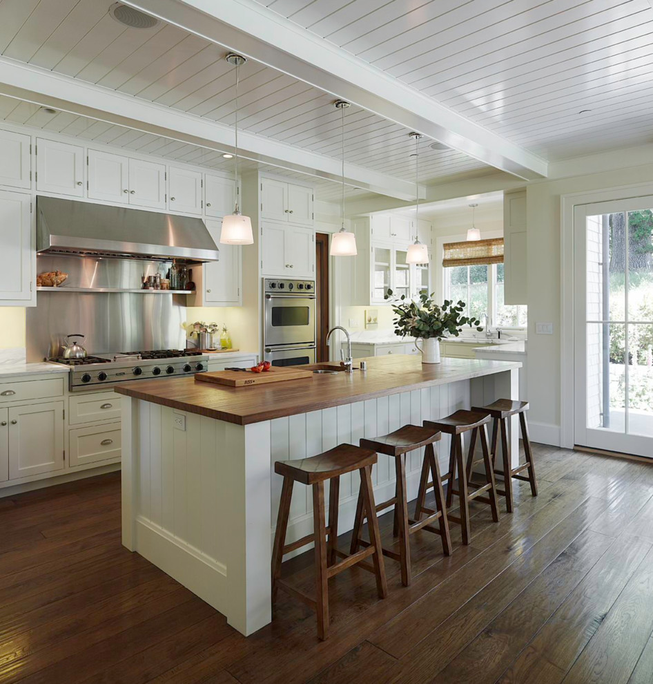 Inspiration for a mid-sized single-wall kitchen in Las Vegas with shaker cabinets, white cabinets, wood benchtops, metallic splashback, medium hardwood floors and with island.