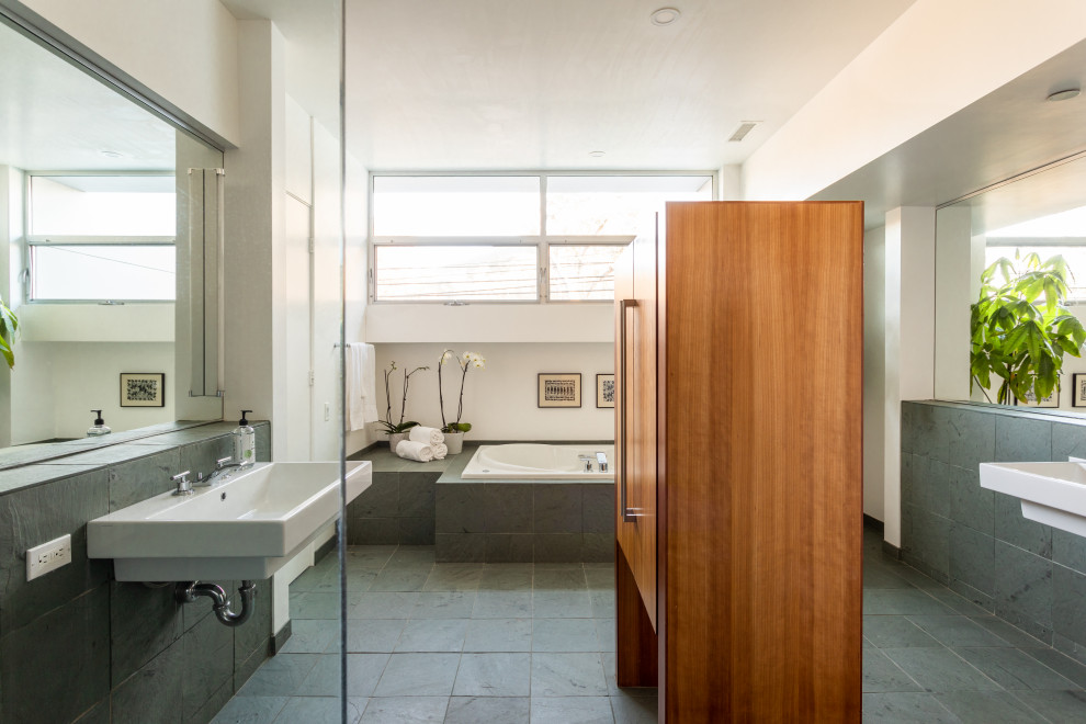 Photo of a mid-sized contemporary master bathroom in Los Angeles with a drop-in tub, white walls, green floor, a double vanity and a floating vanity.