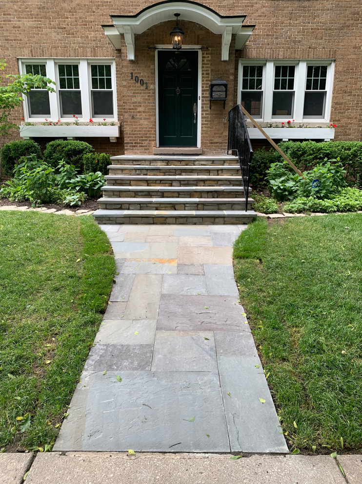 Photo of a mid-sized traditional full sun front yard stone landscaping in Chicago.
