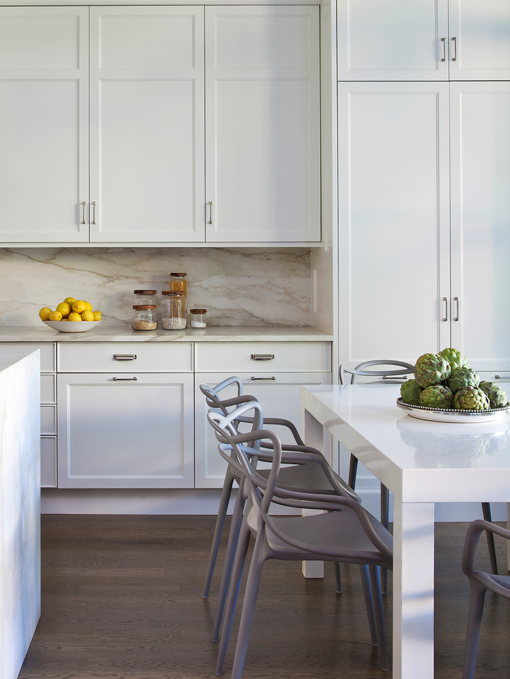 Inspiration for a large transitional single-wall eat-in kitchen in Chicago with an undermount sink, recessed-panel cabinets, white cabinets, marble benchtops, white splashback, stone slab splashback, panelled appliances, medium hardwood floors and with island.