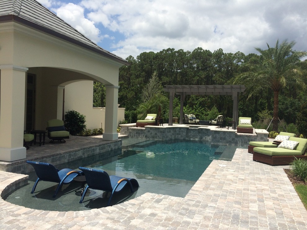 Mid-sized transitional backyard concrete paver and custom-shaped natural pool fountain photo in Orlando