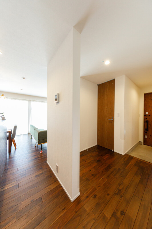 Photo of a medium sized modern hallway in Other with white walls, dark hardwood flooring, a single front door, a medium wood front door, brown floors, a wallpapered ceiling and wallpapered walls.