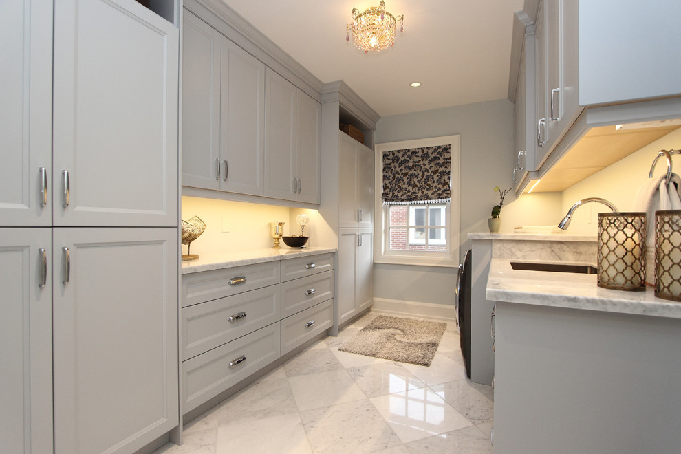 Large traditional u-shaped utility room in Toronto with an undermount sink, recessed-panel cabinets, grey cabinets, marble benchtops, grey walls, marble floors, a side-by-side washer and dryer, grey floor and grey benchtop.