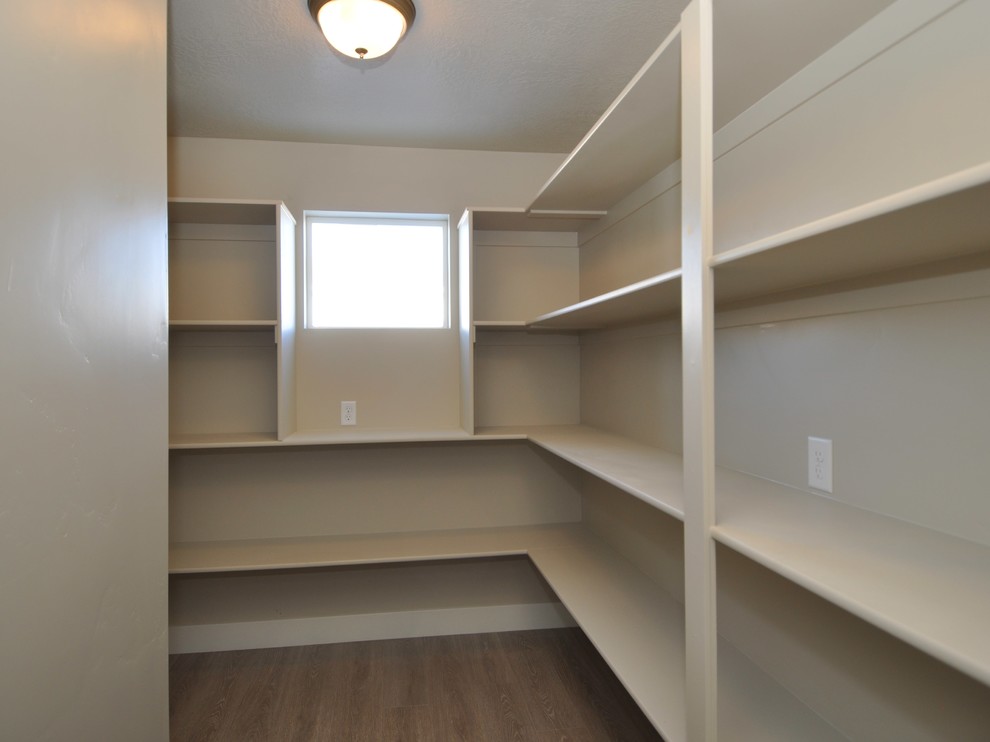 Photo of a large transitional gender-neutral walk-in wardrobe in Salt Lake City with laminate floors.