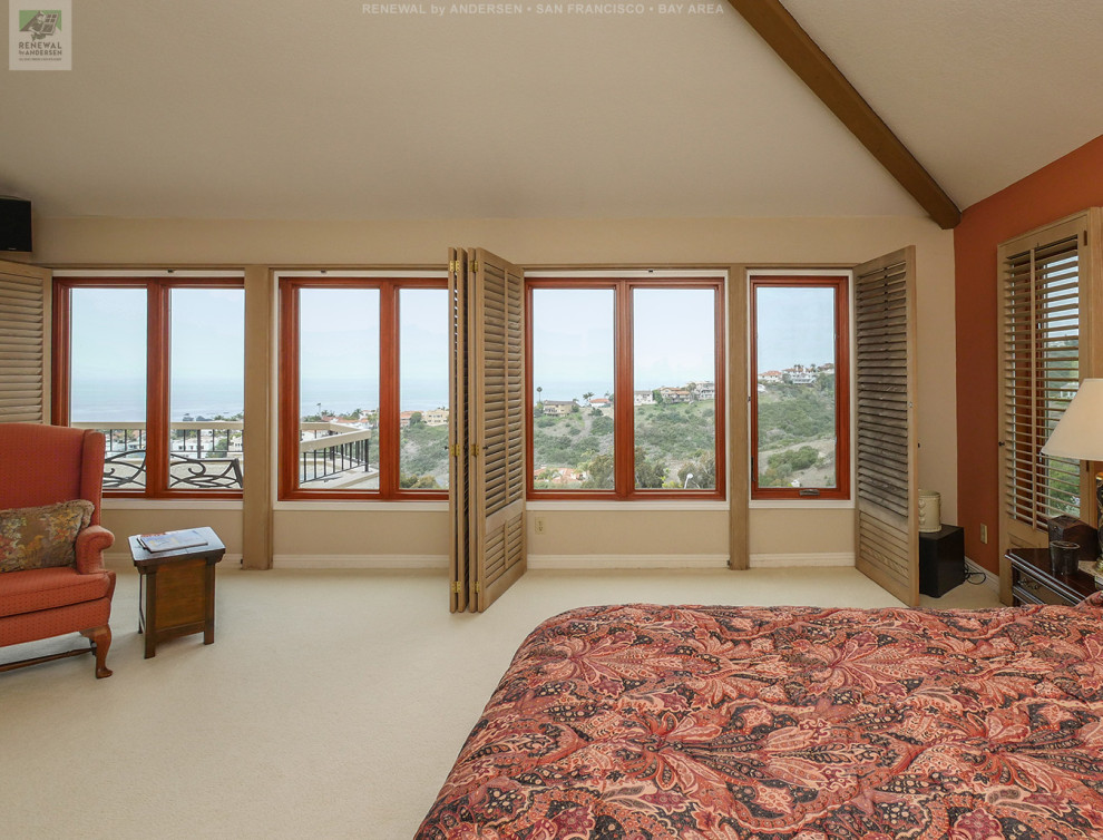 Großes Hauptschlafzimmer mit beiger Wandfarbe, Teppichboden, Kamin, Kaminumrandung aus Backstein, beigem Boden und freigelegten Dachbalken in San Francisco