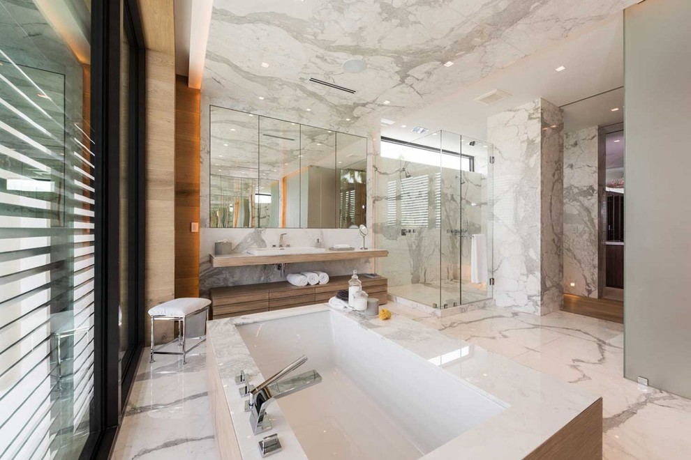 Contemporary master bathroom in Miami with flat-panel cabinets, light wood cabinets, an undermount tub, a corner shower, gray tile, white tile, multi-coloured walls, porcelain floors, a drop-in sink and a hinged shower door.