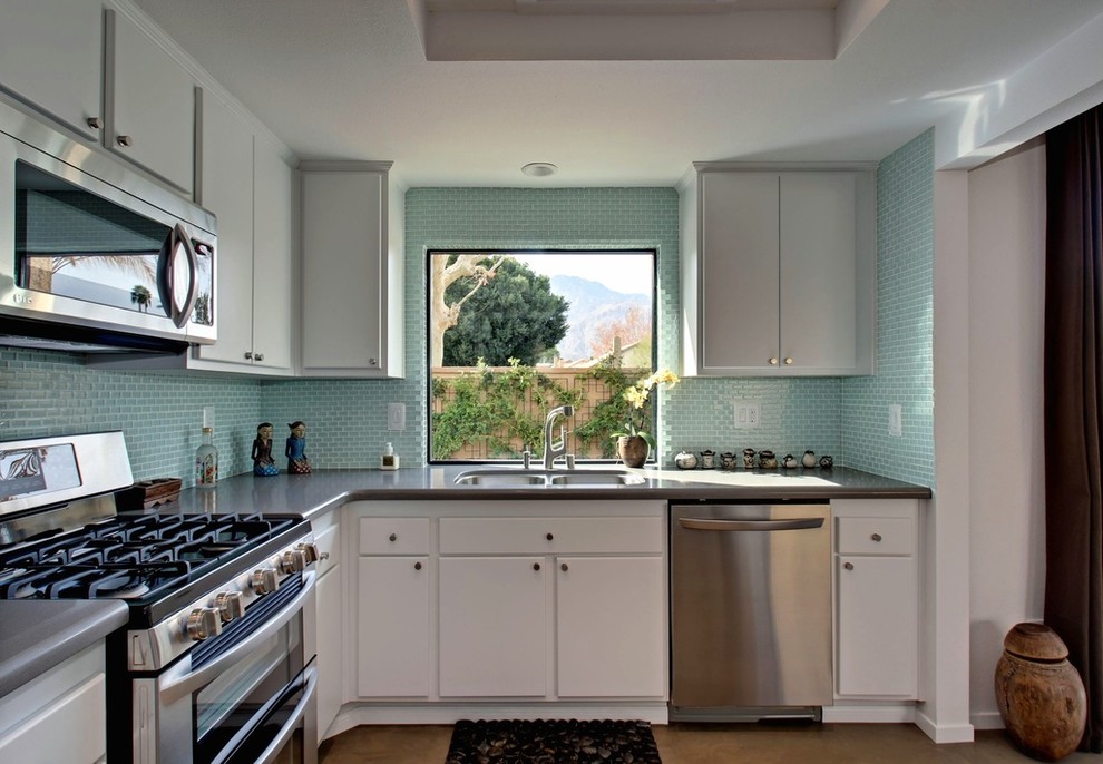 Mid-sized traditional l-shaped separate kitchen in New York with a drop-in sink, white cabinets, blue splashback, mosaic tile splashback, stainless steel appliances and no island.