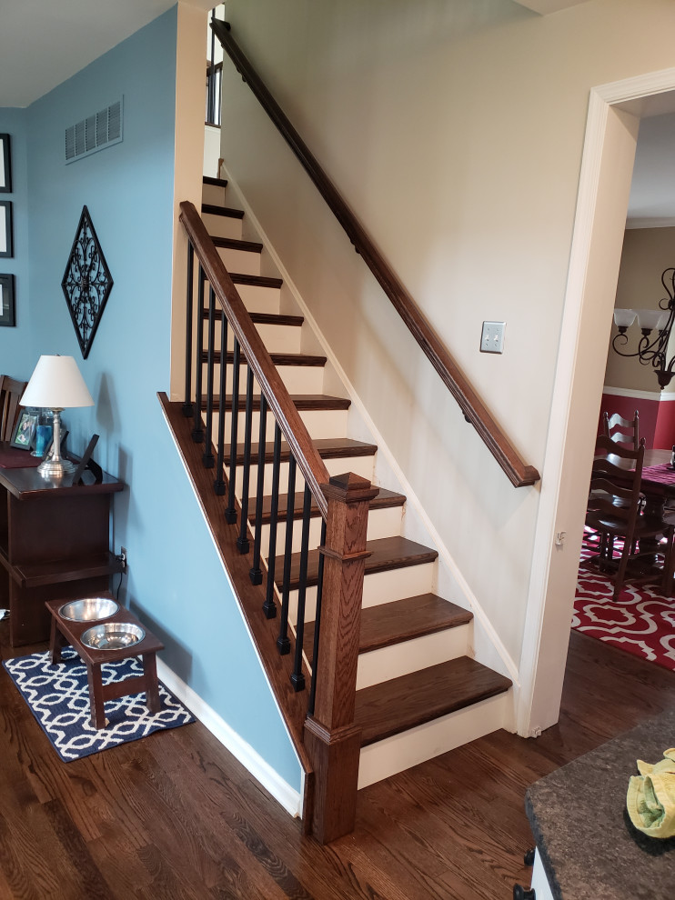 This is an example of a large eclectic wood u-shaped staircase in Philadelphia with painted wood risers and wood railing.
