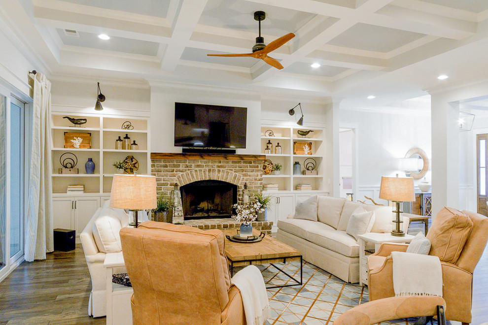 Design ideas for a mid-sized country open concept living room in Atlanta with white walls, dark hardwood floors, a standard fireplace, a brick fireplace surround, a wall-mounted tv and brown floor.