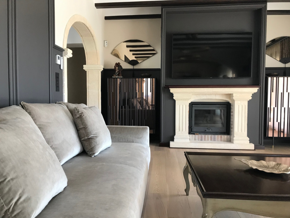 Inspiration for a large traditional living room in Alicante-Costa Blanca with brown walls, light hardwood floors, a standard fireplace, a stone fireplace surround, a wall-mounted tv and exposed beam.