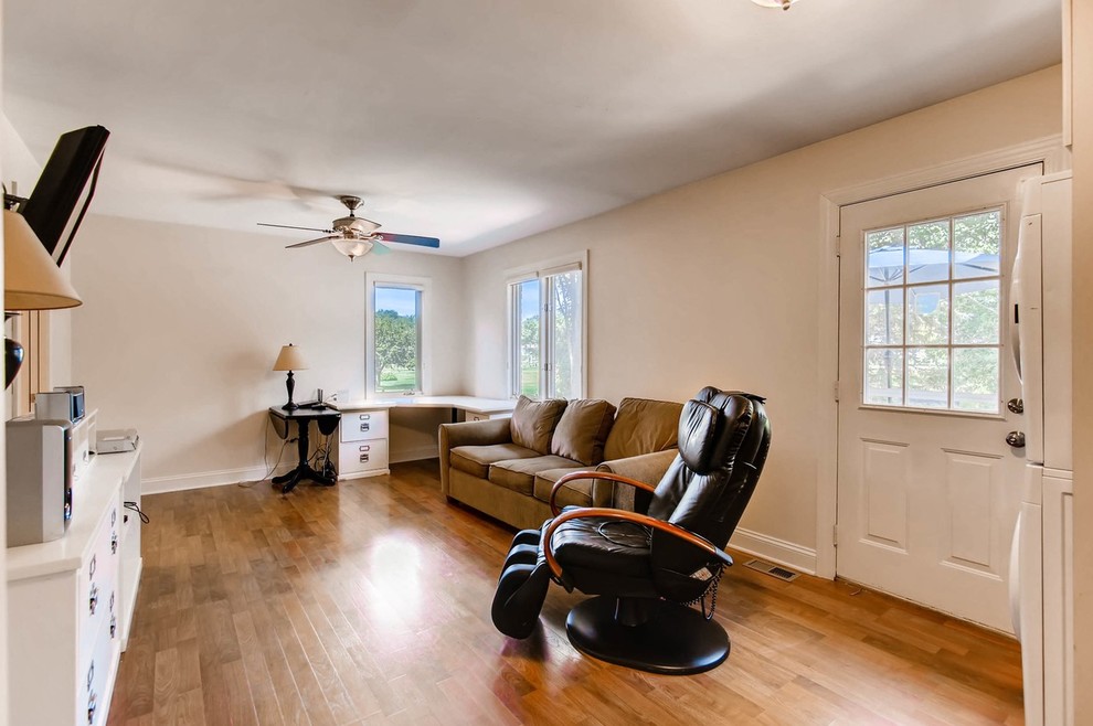 Photo of a mid-sized transitional enclosed family room in Chicago with a game room, white walls, light hardwood floors, a wall-mounted tv, no fireplace, brown floor, wallpaper and wallpaper.