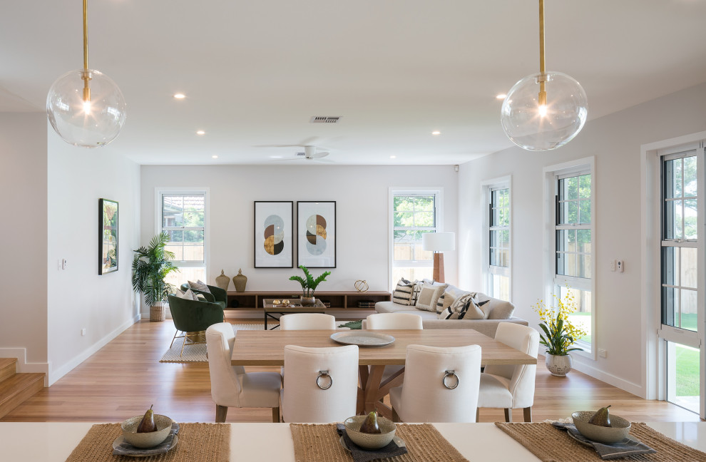 Photo of a contemporary open plan dining in Brisbane with white walls, medium hardwood floors, no fireplace and brown floor.