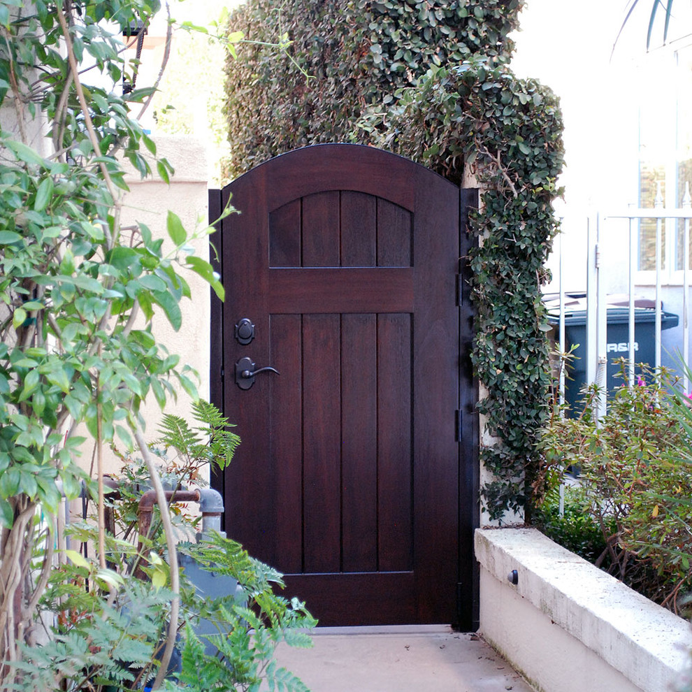 Inspiration for a mid-sized mediterranean front door in Orange County with a single front door and a dark wood front door.