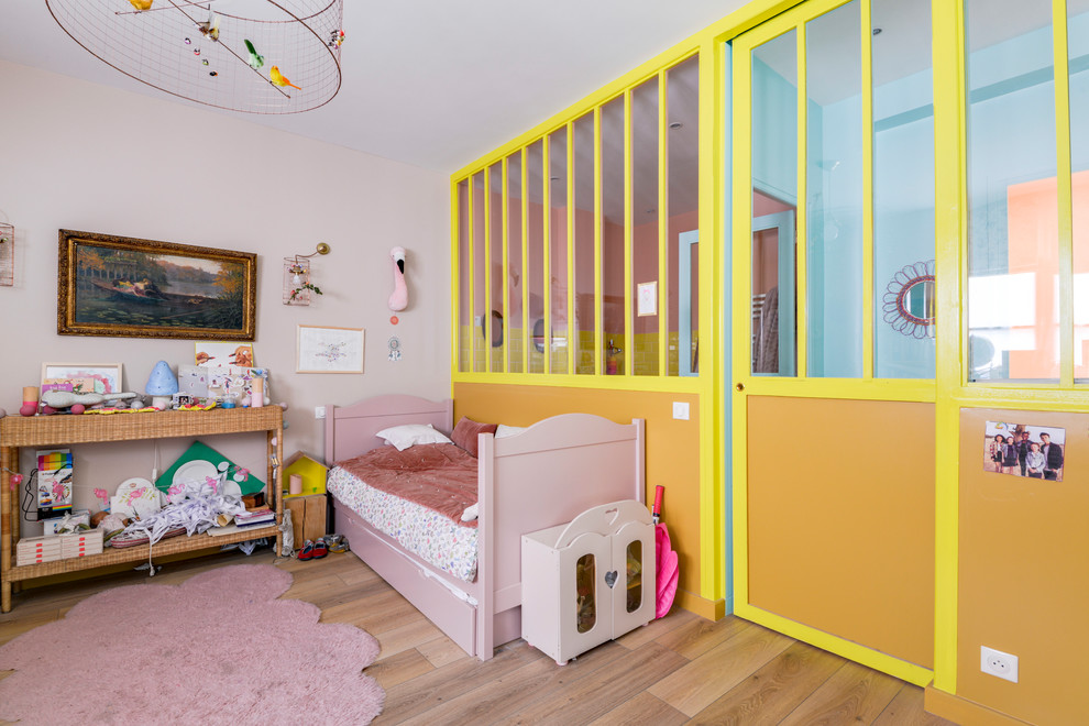 Eclectic kids' bedroom in Paris with pink walls and brown floor.