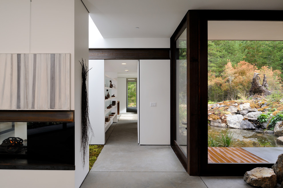 This is an example of a mid-sized contemporary hallway in Seattle with white walls and concrete floors.